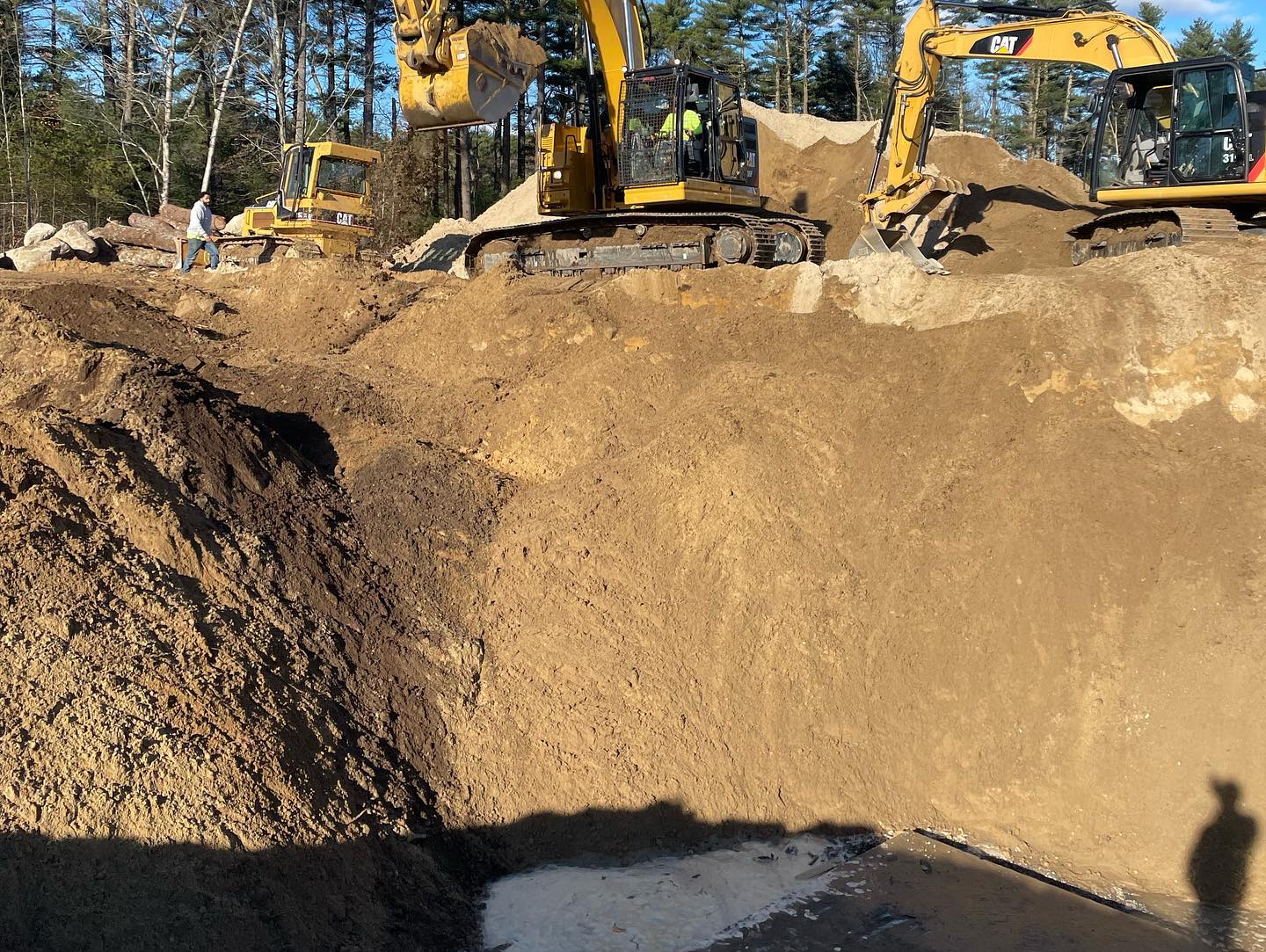Excavators and bulldozer excavating a large construction pit